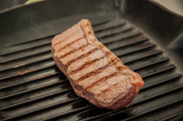 Rare beef rump steak on a griddle pan