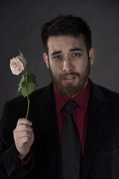 Sad Man in Formal Wear Holding Withered Rose