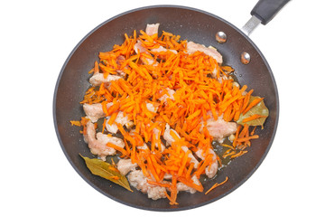 Fried meat with carrots in the pan