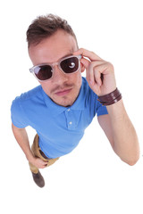 casual young man holds his sunglasses