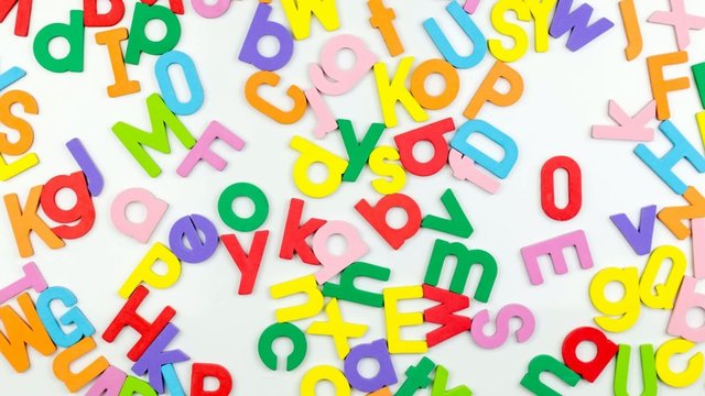 Alphabet magnets being shuffled around, stop motion