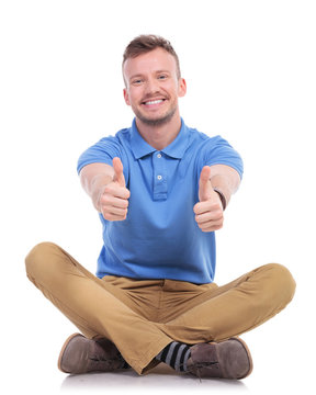 seated young casual man shows thumbs up