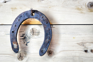 Old rusty horseshoe is hanging on a nail. Easy HDR effect