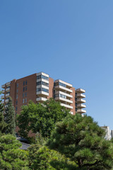 Brown and White Condo Tower in Green Trees