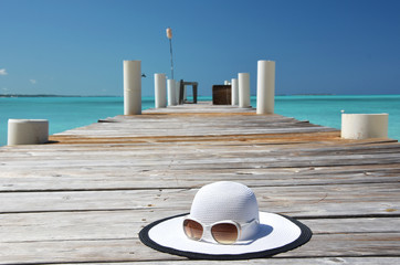 Hat and sunglasses on the wooden jetty. Exuma, Bahamas