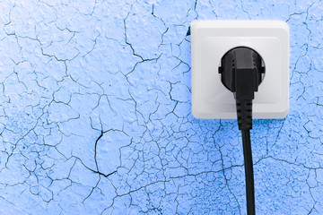 Wall plug socket on cracked wall