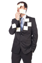 Thoughtful young  businessman with post-it notes on his face and