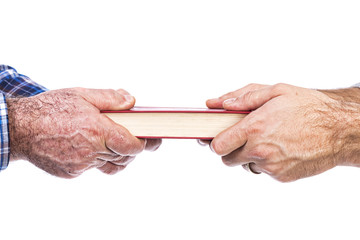 Closeup of mature man´s hand giving a book to his son