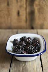 Blackberries in rustic kitchen setting with wooden background
