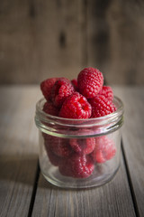 Raspberries in rustic kitchen setting with wooden background