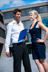 Businessman with board explaining a female colleague a project