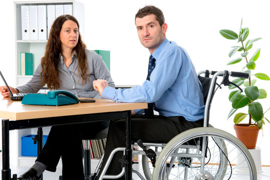 man in wheelchair and his  is female colleague working in the jo