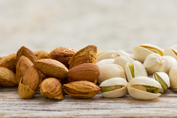 Roasted almonds and pistachios on wood
