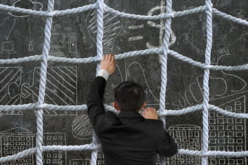 Businessman climbing crisscross rope net on business concept doo