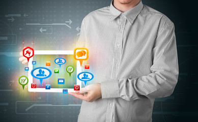 Businessman presenting modern tablet with colorful social signs