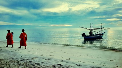 Monks walk on the beach