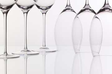 Six wine glasses on a glass desk