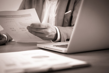 Fototapeta premium Businessman analyzing investment charts with laptop. Accounting