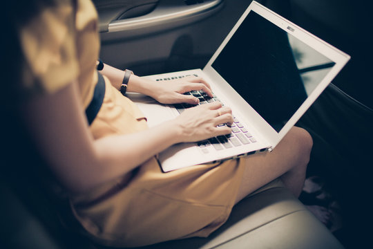 businesswoman with document and laptop in car