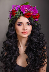 Fototapeta premium beautiful girl with a wreath of orchids on head. Glamorous woman