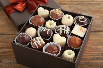 Delicious chocolate candies in gift box on table close-up