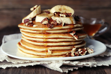 Stack of delicious pancakes with chocolate, honey, nuts and