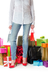 Woman standing before many gifts and shopping bags