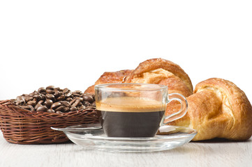 coffee in glass cup with croissants and coffee beans