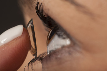 A woman putting on contact lenses