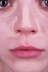 Obraz premium Applying makeup with cosmetic foundation, macro