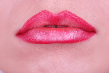 Applying lipstick on lips, macro