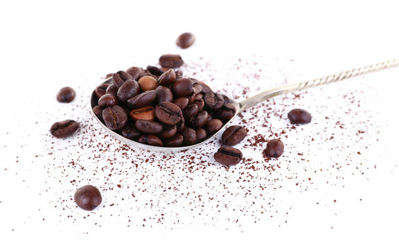 Coffee beans in spoon isolated on white © Africa Studio