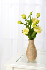 Beautiful bouquet of flowers in vase on window background