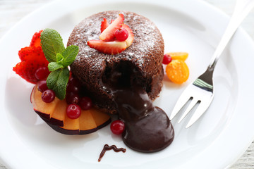 Hot chocolate pudding with fondant centre with fruits, close-up