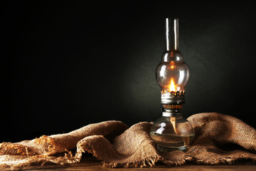 Kerosene lamp with burlap cloth on dark background