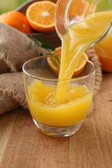 Pouring orange juice from glass carafe,