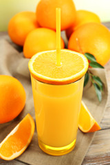 Glass of orange juice with straw and slices