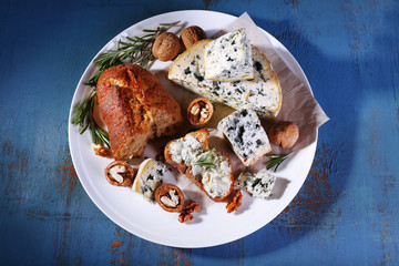 Blue cheese with sprigs of rosemary, bread and nuts