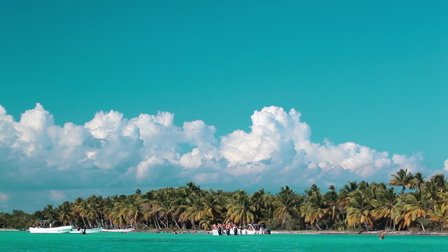 Tropical resort with people  and boats near the beach