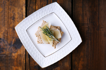 Crispbread with slices of Parmesan cheese with sprig of