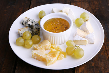 Different sort of cheese with grape and saucer