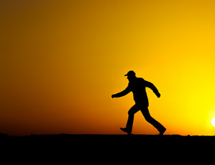 Fototapeta na wymiar Silhouette of man running at sunset