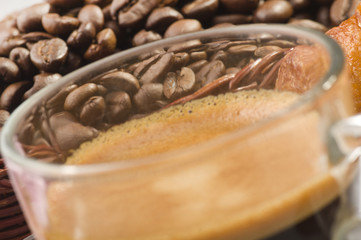 coffee in glass cup with croissants and coffee beans
