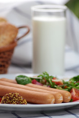 Wiener sausage with ketchup, mustard and salad.