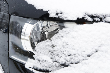 Snowed car headlights in winter