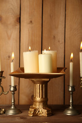 Retro candlesticks with candles on wooden background