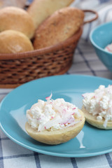 Cottage cheese with radish on a sliced bun.