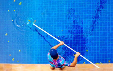 young adult man, personnel cleaning the pool from leaves - 76750367