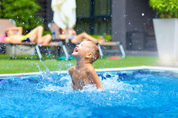 excited cute boy having fun in pool
