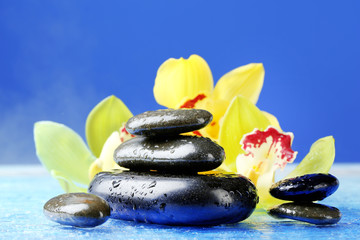 Spa stones with steam and beautiful blooming orchid
